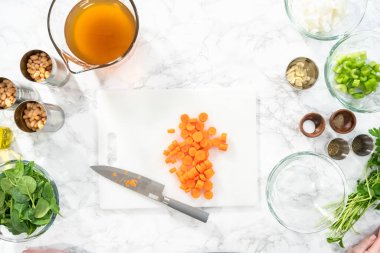 Düz yatıyordu. Beyaz bir kesme tahtasıyla organik havuç kesmek..