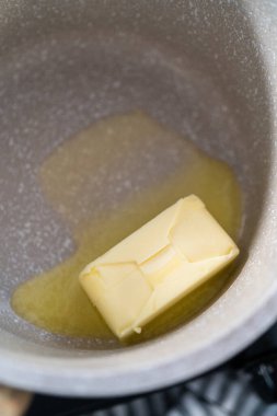 Küçük bir tencerede tuzsuz tereyağı eritmek.