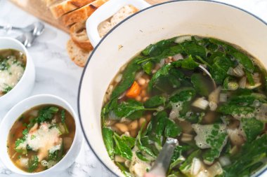 Dökme demir Hollanda fırınında vejetaryen beyaz fasulye çorbası pişirmek.