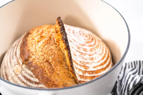 焼きたての小麦のパン生地のパンに エナメル鋳鉄製のオランダのオーブンでパンの防水バスケットのマークが付いています — ストック写真