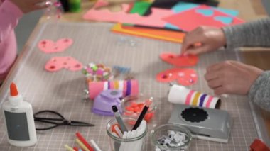Close up view. Kids papercraft. Making paper bugs out of the empty toilet paper rolls and construction paper.