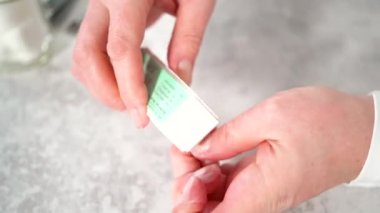 Kadın manikürünü evde basit manikür aletleriyle bitiriyor. Çivi tampon bloğu ile tampon çiviler.