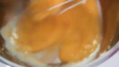 Küçük metal bir kasede organik yumurta çırpmak mutfak çırpıcısıyla.