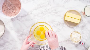 Düz yatıyordu. Adım adım. Kırmızı kadife kek pişirmek için bardakta ıslak malzemeler karıştırıyorum..