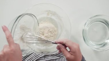 Düz yatıyordu. Ev yapımı ekmek yapmak için karıştırma kabının içindeki malzemeleri karıştırıyorum..