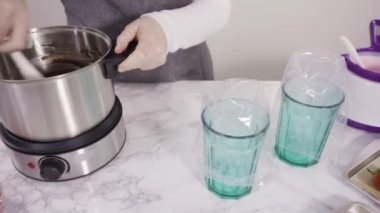 Adım adım. Çikolata parçacıkları eriyen kaplarda eriyor..