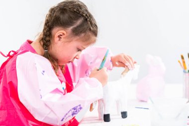 Küçük kız COVID-19 salgınında evde uzaktan öğrenim için sanat projesi üzerinde çalışıyor..