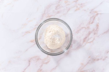 Düz yatıyordu. Elmalı Sharlotka keki pişirmek için karışımı büyük bir bardakta karıştırıyorum..