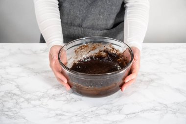 Büyük bir bardaktaki malzemeleri karıştırarak naneli çikolatalı kekler pişiriyorum..