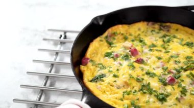 Fırınlanmış ıspanak ve jambonlu frittata dökme demir tavada..