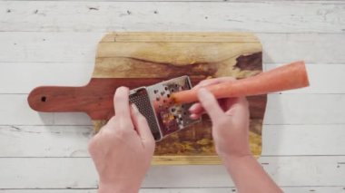 Zaman aşımı. Ağaç kesme tahtasında rendelenmiş organik turuncu havuç..