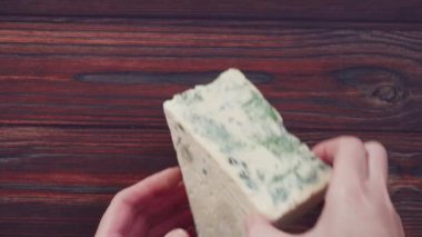 Düz yatıyordu. Koyu ahşap arka planda büyük bir dilim mavi peynir..