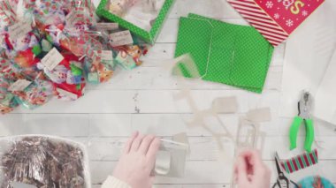 Düz yatıyordu. Adım adım. Ev yapımı macadamia şekerlemesi küçük hediye paketlerine konuyor..