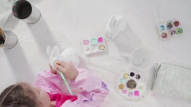 Düz yatıyordu. Evde resim dersinde kağıt heykel boyayan küçük bir kız..