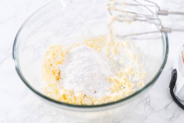 Krem peynirli çiseleme sosu hazırlamak için büyük bir bardakta karıştırma malzemesi..