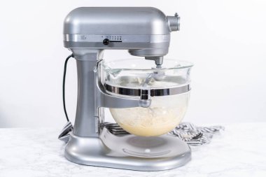 Ev yapımı brioche çörekleri pişirmek için mutfak mikserindeki malzemeleri karıştırıyorum..