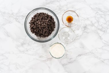 Flat lay. Preparing chocolate ganache in a glass mixing bowl.