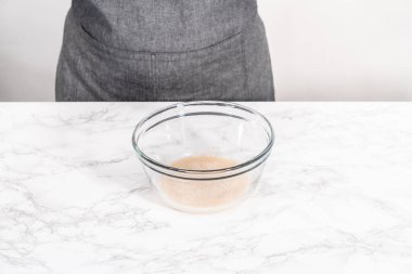 Tarçınlı tatlı pizzası hazırlamak için cam bir kasede pizza hamuru yetiştiriyorum..