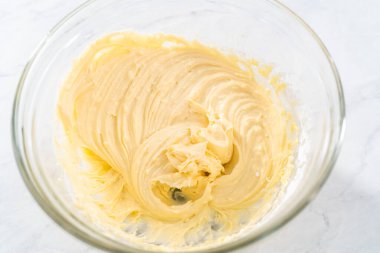 Krem peyniri kek yapmak için büyük bir bardakta karıştırma malzemesi..