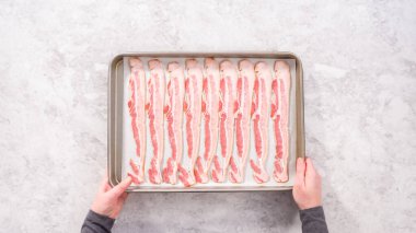 Düz yatıyordu. Adım adım. Pişmemiş pastırma şeritleri ve beyaz parşömen kağıtları..