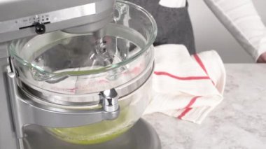 Adım adım. Mutfak mikserinde tek boynuzlu at kurabiyesi pişirmek için malzemeler karıştırılıyor..