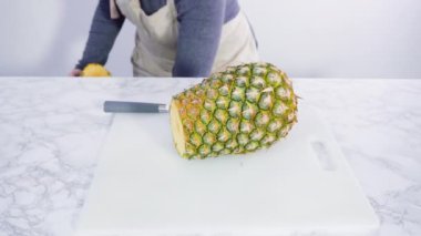 Adım adım. Beyaz bir kesme tahtasıyla ananas kesmek.