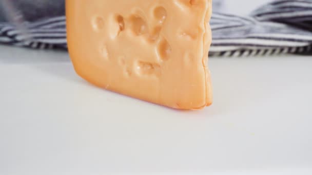 白色切菜板上的一大块半软片脱脂奶酪 — 图库视频影像