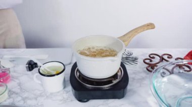 Zaman aşımı. Adım adım. Küçük elektrikli ocağın üzerinde küçük bir tencerede karamelize şeker.