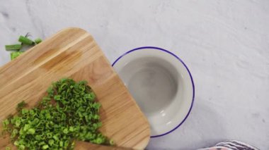 Düz yatıyordu. Adım adım. Ağaç kesme tahtasında organik yeşil soğan doğramak.