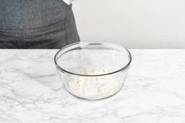 Kuru malzemelerle büyük bir bardakta çırpma kabını karıştırıp mini vanilyalı kekleri ombre pembe tereyağlı kremayla karıştırıyorum..