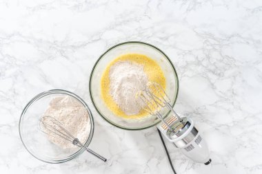 Düz yatıyordu. Malzemeleri karıştırıcı ile karıştırarak büyük bir karıştırma kabında yumurta likörü pişirmek..