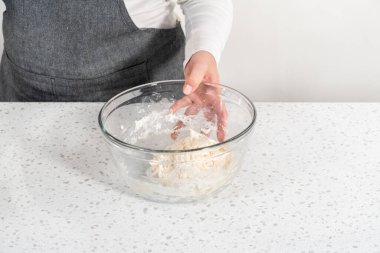 Büyük bir cam kasede ahşap bir kaşıkla karıştırılan malzemeler naan dippers pişirir..