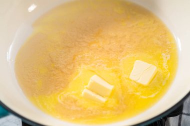 Ispanaklı sarımsaklı karides makarna hazırlamak için dökme demir tavada marine edilmiş karides..