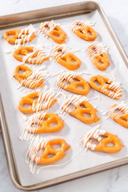 Çikolata soslu krakerlerin üzerine erimiş çikolata serpiştirmek..