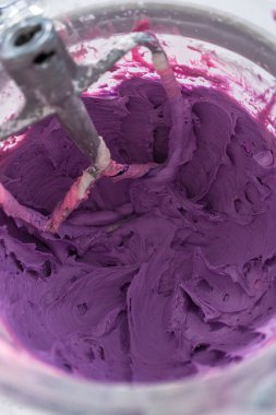 Mutfaktaki elektrikli mikserin içeriğini karıştırıp tereyağlı krema yapıyorum..