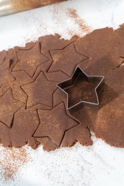 Kurabiye kesiciyle hamurdan yıldız şeklinde çikolatalı kraker kesmek..