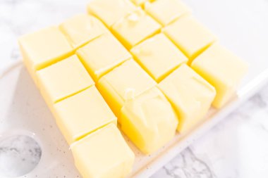 İtalyan kreması hazırlamak için tuzsuz tereyağı çubukları küp şeklinde kesilmiş..