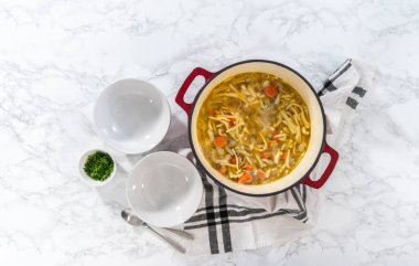 Düz yatıyordu. Beyaz seramik çorba kaselerinde kluski şehriyeli tavuk çorbası servis ediyorum..