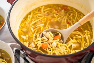 Beyaz seramik çorba kaselerinde kluski şehriyeli tavuk çorbası servis ediyorum..