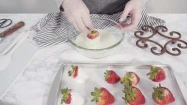 Adım adım. Çikolata kaplı çilek hazırlamak için organik çilekleri erimiş çikolatayla bir kaseye daldırmak..