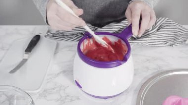 Adım adım. Çikolata kalıplı şekiller için erimiş kırmızı çikolata parçaları..