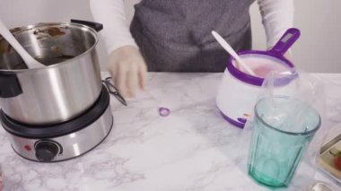 Adım adım. Çikolata parçacıkları eriyen kaplarda eriyor..