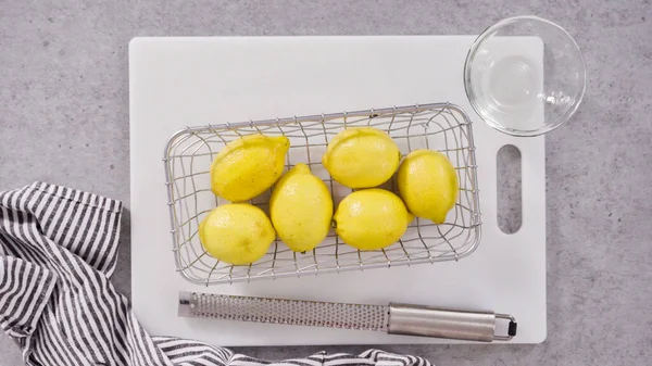 Flat lay. Whole lemons in a wired basket to bake a lemon pound cake.