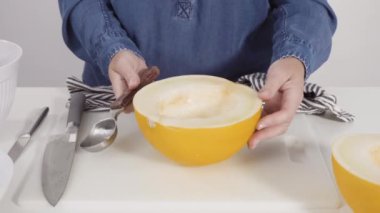 Adım adım. Beyaz kesme tahtasında kaygan altın çiğ taneli kavun.