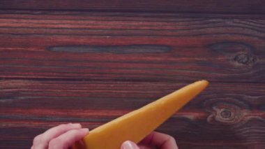 Düz yatıyordu. Büyük bir dilim füme gouda peyniri, ahşap arka planda..