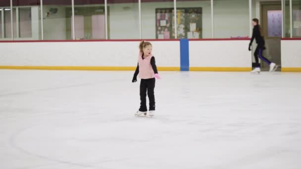 小さな女の子練習フィギュアスケート要素上の屋内アイススケートリンク — ストック動画