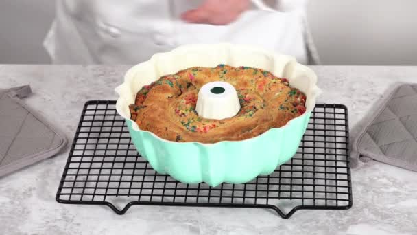焼きたてのファンフェッティ バントケーキをバンドケーキ パンから取り除く — ストック動画