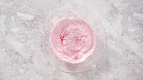 평평하게 분홍색 음식의 바닐라 버터크림에 혼합하여 짓이긴 케이크를 장식하는 — 비디오
