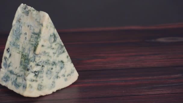 Koyu Ahşap Arka Planda Büyük Bir Dilim Mavi Peynir — Stok video
