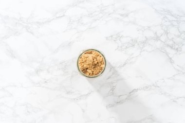 Düz yatıyordu. Açık kahverengi şeker mermer tezgahın üstünde.